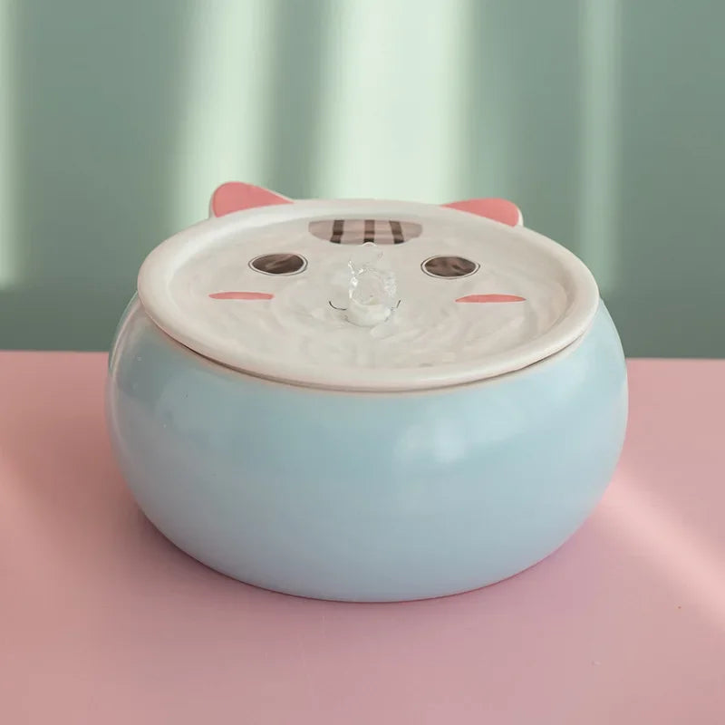 Fontaine pour animaux en céramique bleue avec design de chat et système de filtration d'eau.