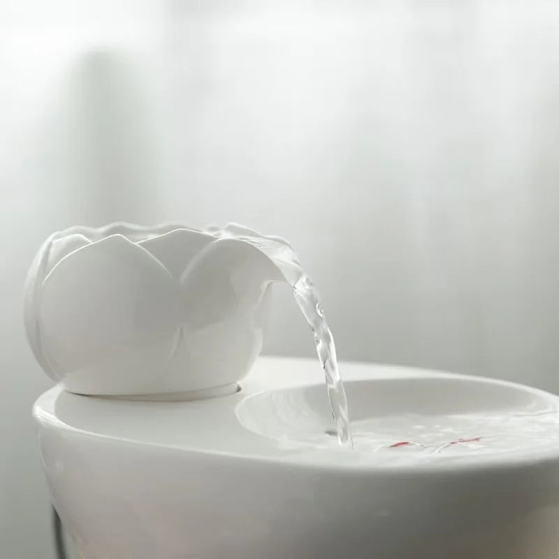 Fontaine décorative en céramique blanche en forme de fleur, avec eau coulant doucement.