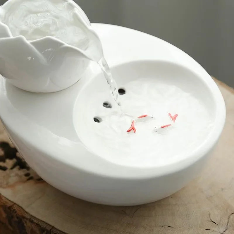 Fontaine en céramique blanche avec poissons décoratifs et arrosage apaisant, design moderne.